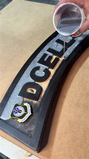 Metallic grey epoxy hitting different on this one. ⚡️ We created this custom “DCELL” tab for our customer! It features the United States Air Force Special Operations Command emblem and the 24th Rapid Deployment Squadron patch within the tab, sealed in epoxy and framed with crisp black lettering and border.😎 #epoxy #epoxypour #AFSOC #epoxyart #fyp