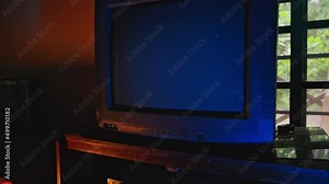 Camera dolly. Man with remote control changes channel on tv with no signal