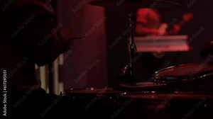 Energetic drum beats: closeup of young latino drummer's hands and drums delivering a vibrant live performance in a concert under colorful lights