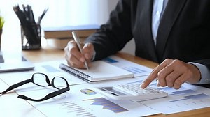 business woman using a calculator to check financial accounts check the company's expenses and budget.