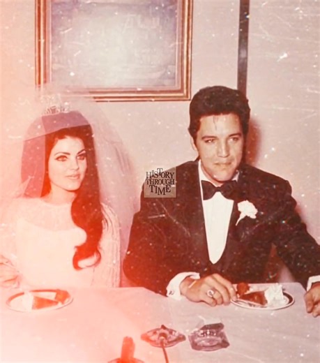 "Elvis and Priscilla Presley are photographed during a press conference held shortly after their wedding ceremony in Las Vegas, May 1967. Surrounded by a select group of family, friends, and reporters at the Aladdin Hotel, the couple shared smiles and soft-spoken words as flashbulbs captured the moment. Elvis, in a black brocade tuxedo, and Priscilla, in a beaded chiffon gown and bouffant veil, appeared radiant and composed. The brief yet elegant event was followed by a champagne breakfast recep