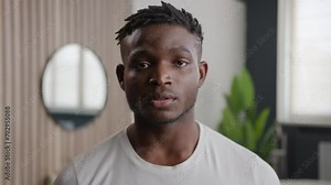Portrait of African American ethnic young guy morning hygiene in home hotel bathroom male beauty routine dermatology shaving grooming shampoo hair care healthy man looking at camera health wellness