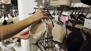 A young woman buys a bra in a lingerie store. Shopping in stores