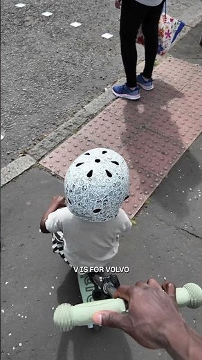 2-year-old car spotter on a tiny scooter