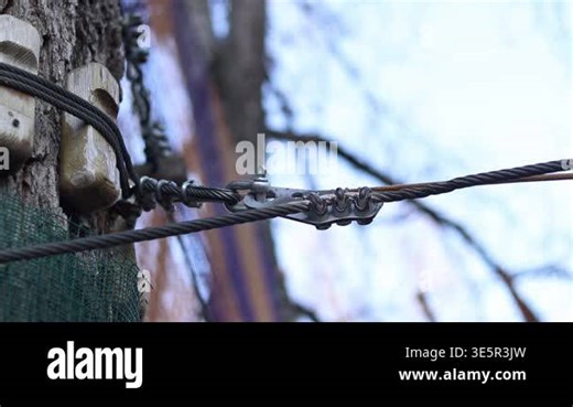 Steel cable fastening system. Steel cable clamps are known as rope clamps or U-shaped clamps. Clamps are used to form loops or connect the ends of cables. Fragment of a rope park fastening Stock Video Footage - Alamy
