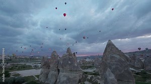 Hot air balloons fill the sky above the stunning geologic structures of Cappadocia Turkey