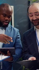 Supervisor and employees attend a status update meeting with their progress portfolios on the current business project. Team leader reviewing marketing strategies and budget planning. Camera A.