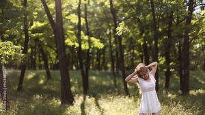 beautiful girl in white dress dancing in the forest