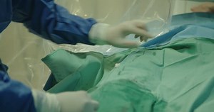 Surgeons preforming a cardiac catheterization in a hospital