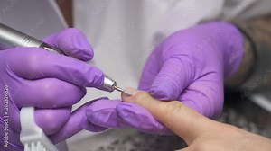 Nail technician using an electric file to shape and prepare a client nails during a manicure Stock Video