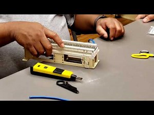 Technical Instructor Mr. William Diaz terminating a 66-block with a punch down tool and Cat5e cable