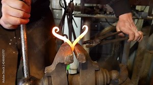 Blacksmith Bending Hand Forged Heart Blacksmith Product with Scrolling Tongs in Blacksmith Vice to Shape Hot Steel