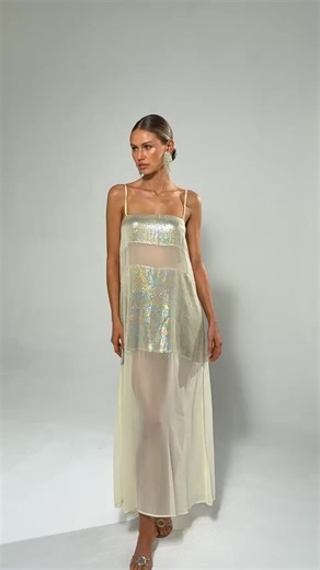 The Eli Gold Panel Dress combines elegance with contemporary design through strategically placed sheer chiffon panels that create visual interest and movement. This sophisticated piece transitions seamlessly from cocktail events to upscale gatherings, offering a refined silhouette enhanced by flowing fabric.