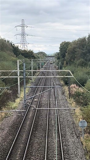 Class 323 passing under a footbridge near Macclesfield