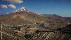 Long shot of the grandeur of Mount Damavand in all its summer splendor, surrounded by a beautifully diverse landscape.