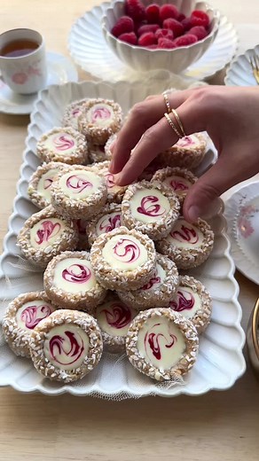 RASPBERRY MACADAMIA COOKIES WITH WHITE CHOCOLATE (NO BAKE) #raspberries #food #recipe #cookies #chocolate #nobake #fy #fyp #foryoupage RASPBERRY MIXTURE 200 g raspberries 60 g granulated sugar COOKIE DOUGH 200 g Maria biscuits 75 g macadamia nuts (unsalted) 100 ml heavy cream (unwhipped) 250 g white chocolate COATING Grated coconut TOPPING 125 g white chocolate Place the raspberries and sugar in a skillet over medium heat. Simmer gently for 5-7 minutes, stirring regularly. Place a sieve over a b