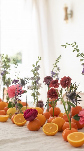 No vase, no problem! Create a whimsical citrus floral arrangement for your spring gathering in minutes! 🍊💐 SAVE this reel for your next spring gathering! How to Make Citrus Floral Arrangement 🍊 Gather fresh flowers, citrus (oranges, lemons, limes), and wooden skewers. Cut some citrus in half and leave others whole for variety. Use a wooden skewer to poke a hole in the citrus, then insert a single stemmed flower. If stacking citrus, cut a skewer to hold them in place. Spread them around the ta