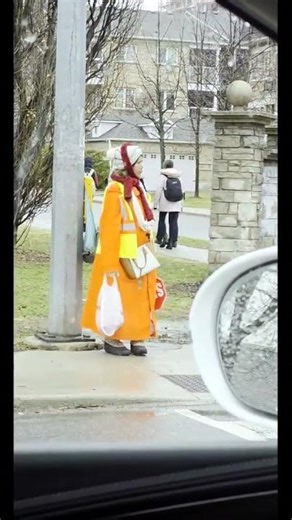 №1595_Y.Z. A woman helps schoolchildren cross the road safely.Rainy day. Sketches from a car window.