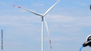 Wind turbine propellers rotating against cloudy sky. Modern electric automobile charged by alternative energy near windmill low angle shot Stock Video