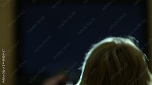 woman with remote control switching tv channels back of the head a woman watching