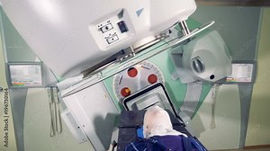 Massive linear accelerator is revolving around a male patient