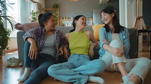 Group of female friends enjoying life and having fun at home. Girls day in the apartment. Young women spending time together chatting and making activities in the living room. Concept about lifestyle