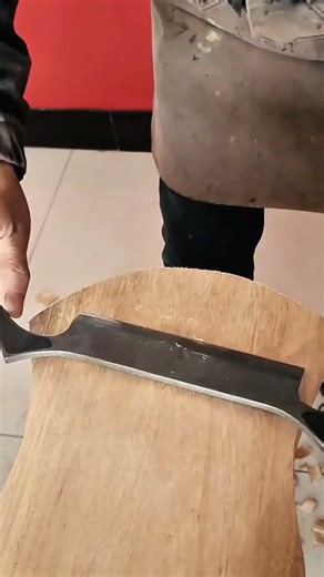 shaving and smoothing a wooden surface with a sharp manual drawknife tool for a refined craft finish