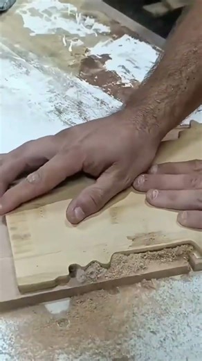 Cutting a light brown wooden board surface precisely using professional electric router machine tool