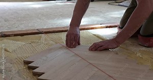 Worker installing wood parquet.Construction in a renovated room installation of parquet.