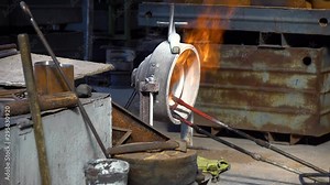 firing of metal parts in the factory, Hardening of parts in the furnace at the factory, male worker firing fiery steel blocks at the factory, Metal annealing with a gas burner at the fact