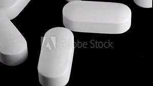 White oblong pills tracking shot close-up. Dependence and drug addiction. Dosage, and prescription refill. Vitamins, antipyretics and antidepressants.