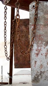 In quiet shipyard, neglected main rotor reveals its rusty surface, poised for much-needed restoration. Chains hang heavy, echoing stories of past voyages and promise of revival ahead.