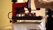 Make a print on t-shirts. Press presses the t-shirt and makes a...