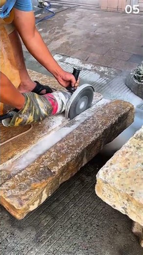Strong hands guiding saw through solid stone slab