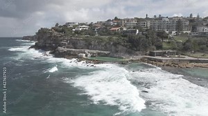 Rock Pool Of Bronte Baths In Eastern Suburbs With Foamy Waves At Bronte Beach In NSW, Australia. - Aerial Pullback Shot