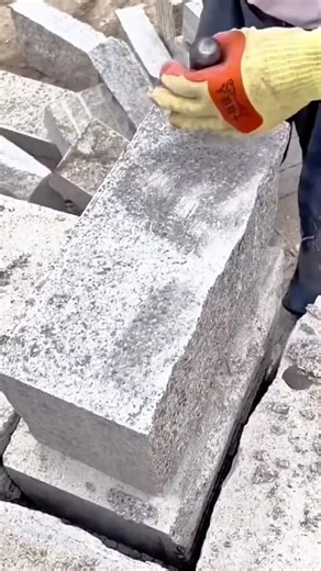 Chiseling and shaping rough granite blocks precisely using hammer and pointed chisel tool