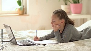 Cute child use laptop for education, online study. Girl has homework at home schooling. Communication with the teacher remotely.