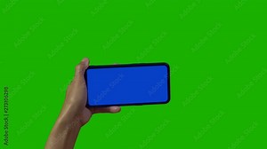 Phone in the hand close up isolated at green background. Phone screen is blue chroma key, background chroma key green screen. Footage for mobile ads, app promo.