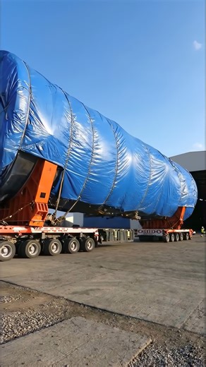 This Giant Load Barely Fits Out of the Factory! 😳 Watch as a heavy-haul transport team carefully moves a massive industrial component wrapped and secured for long-distance travel. With multi-axle trailers distributing weight evenly, every inch of clearance matters as the load exits the facility. Oversized transport like this requires route planning, structural analysis, escort coordination, and expert driving skills. The scale is unreal, look at the size compared to the building! #fblifestyle #