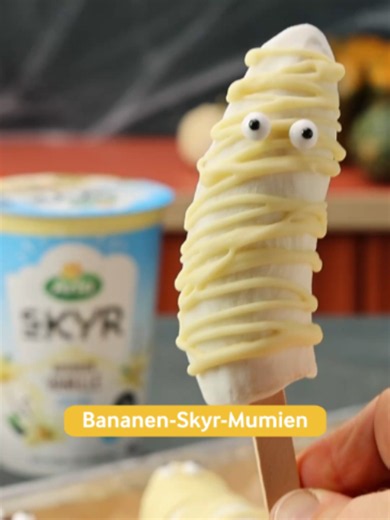 Diese Mumien sind aus ihrem Grab gestiegen, aber keine Sorge: Sie sind eiskalt und zuckersüß. 🍌👻🧟 Gefrorene Bananen-Skyr-Mumien Zutaten: 4 Bananen 300 g Arla® Skyr Vanille 3 TL Erdnussbutter 20 g Zartbitterschokolade 20 g weiße Schokolade 16 Zuckeraugen 8 Eisstäbchen aus Holz Zubereitung: 1. Bananen schälen und halbieren. 2. In jedes Schnittende einen Holzstiel stecken, auf ein Blech mit Backpapier legen und mindestens 2 Stunden einfrieren. 3. Die gefrorenen Bananen in Arla® Skyr Vanille tauc