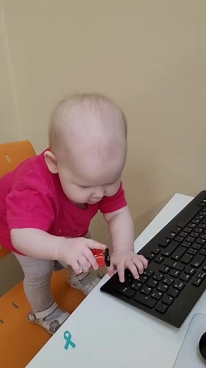 Curious Toddler Interacts with Computer Keyboard