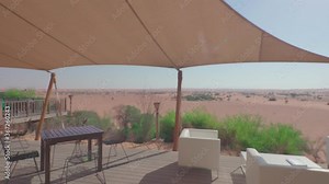 Terrace with panoram view of the desert. There are cafe tables on the terrace. Dubai, UAE.