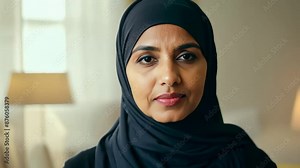 Smiling pretty muslim woman wear black hijab. Middle eastern girl portrait. Religious lady look at camera. Beautiful female arab person face closeup. Happy arabian model concept. Home background.