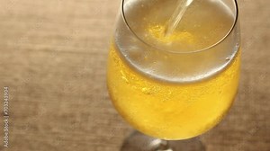 light lager beer. Golden liquid is poured into the glass, causing many bubbles,
