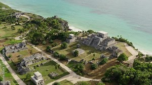 Drone video of the Mayan pyramids. Ancient buildings with temples stand on a rock by the sea in a beautiful landscape in the historic city of Tulum. Aerial view Cancun Mexico.
