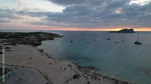cala comte beach with boats, stunning ibiza sunset sky. Amazing aerial top view flight descending drone 4k
