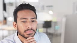 Business man reading information on a computer screen while working...