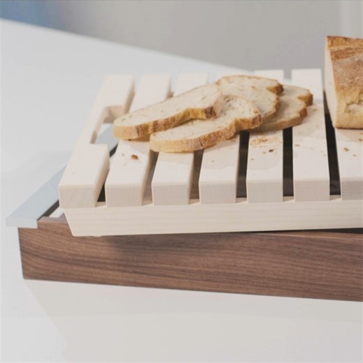 The contrasting maple and walnut wood brings natural beauty to the kitchen, while the aluminum handles add a modern accent and ensure comfortable handling. This versatile board is not only perfect for slicing bread, but also for stylish serving at the table. Project by @bulthaup | bulthaup