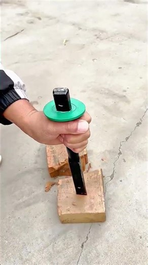 Testing the durability of a steel chisel by striking it against solid bricks on a concrete surface