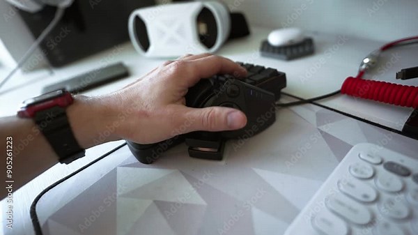 Close-up of a gamer's hands on the desktop manipulating and pressing keys on a special gaming keyboard. Concept: The use of special gadgets for professional gaming.